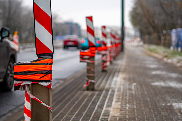 istock Winter warning posts with red-white stripes placed along the repaired street create a clear safety barrier for ongoing roadwork activities 2249884761