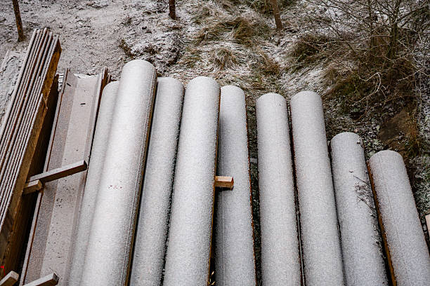 Winter steel pipes covered with a thin frost layer arranged at the construction site creating an industrial composition of technical material