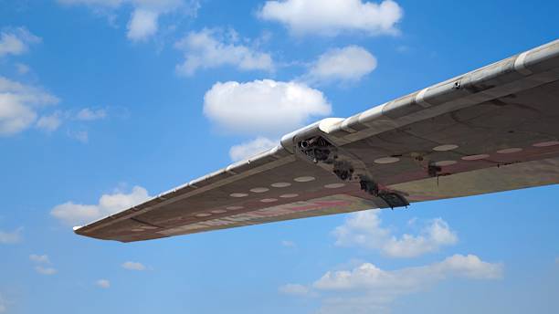 Under the airplane wing. The sky among clouds.
