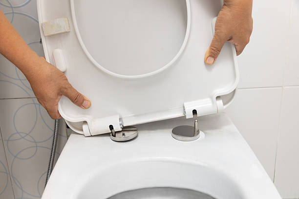 istock Worker replace hinge rubber plug and Screws for Toilet Seat 2249887910