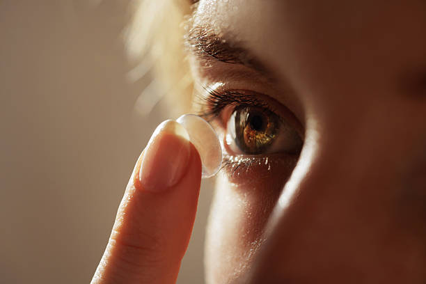istock Woman inserting soft contact lens on brown eye for vision correction close up 2249889206
