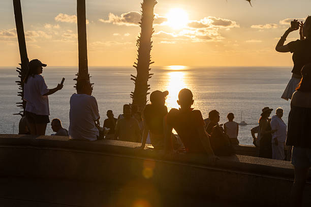 02 December 2025, Phuket Island - Thailand.Tourists gather at the Promthep Cape viewpoint in Phuket as the sun sets over the Andaman Sea. Known as a major tourist landmark, Promthep Cape attracts large numbers of visitors daily due to its panoramic scenery and status as a signature viewpoint of the island.