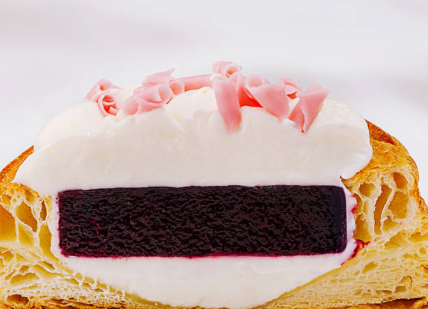 Delicious cream-filled pastry topped with raspberry jelly and whipped cream