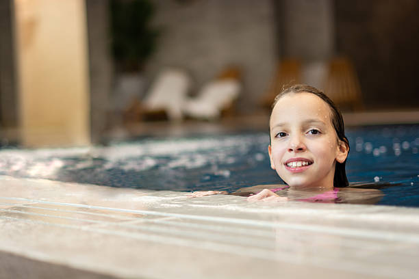 istock Girl smiling having fun in swimming pool at spa 2249891825