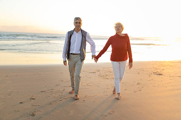 istock Senior couple walking on the beach at sunset holding hands 2249892196
