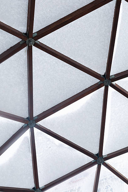 Close-up of triangular geometric construction elements covered with winter snow. Concept of architectural geometry, abstract winter texture and scientific design themes.