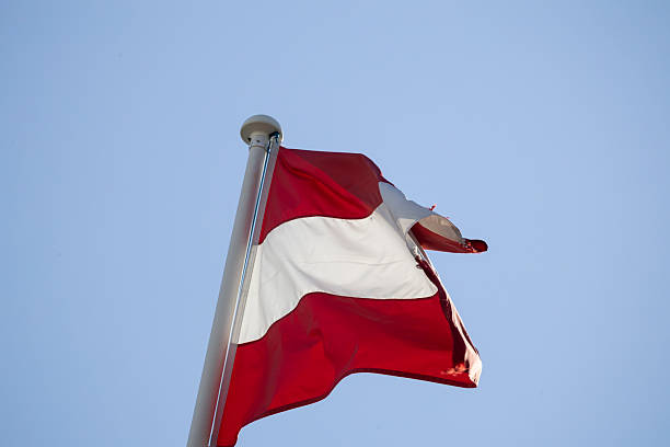 istock Austrian national flag waving against blue sky 2249896911