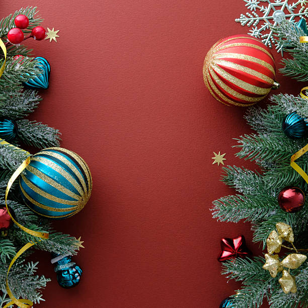 istock Square Christmas composition with two borders of pine branches, vintage baubles, Xmas decorations on dark red background. 2249897775