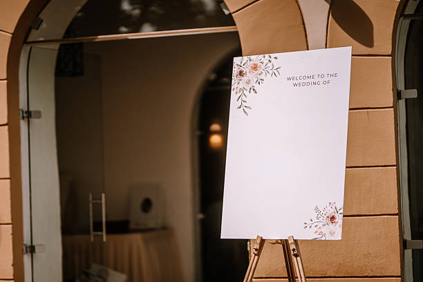 Wedding welcome sign with floral design on easel, set in a charming venue, providing ample copy space for personalized messages and enhancing the festive atmosphere