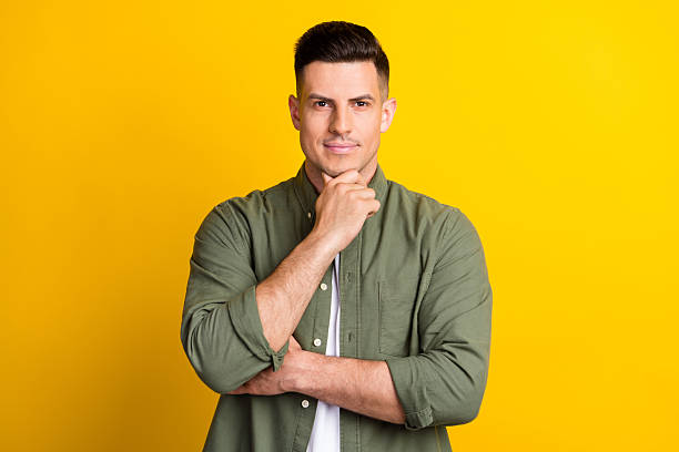 istock Portrait of attractive content cool guy touching chin making decision isolated over bright yellow color background 2249898942