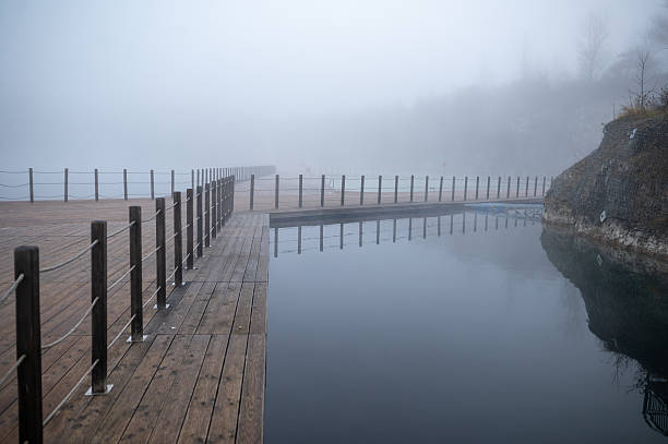 istock Foggy Lakeside Boardwalk Scene 2249900102