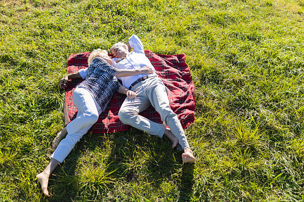 istock Senior couple relaxing on picnic blanket in grass 2249901382