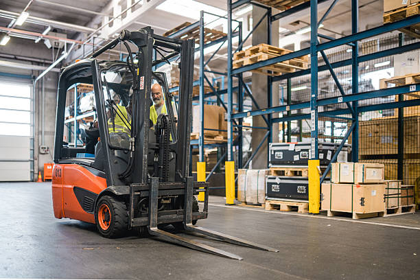 istock Diverse Warehouse Team Operating Orange Forklift In Brightly Lit Distribution Center 2249901910