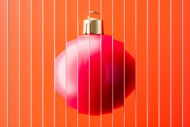 Group of three red vertically striped Christmas balls. Baubles hanging on strings against burgundy red background. Christmas decoration, festive atmosphere concept. Selective focus, copy space.