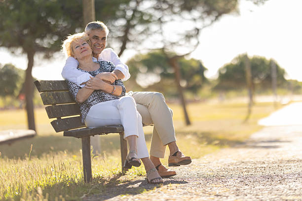 istock Senior couple embracing on park bench enjoying retirement 2249904585