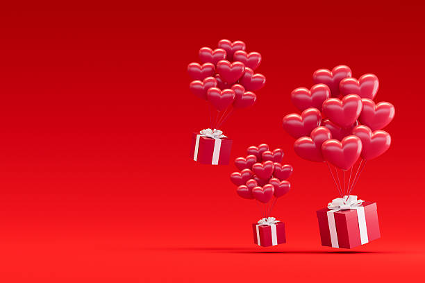 istock Gift Boxes Lifted by Heart Shaped Balloons on Red Background, Valentine's Day Concept 2249907340