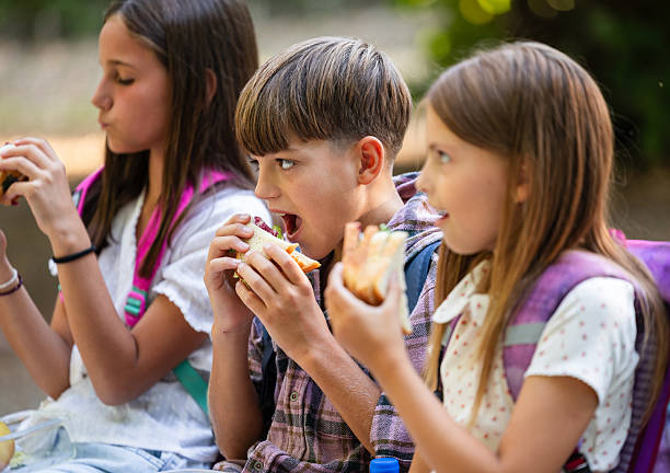 istock Kids sitting outside and enjoying school lunch 2249907698