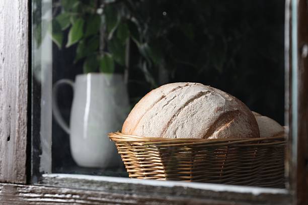 Fresh homemade bread in wicker basket, view through window
