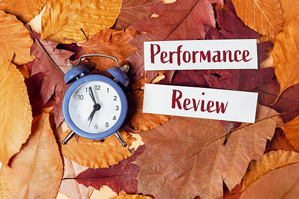 istock Blue alarm clock placed on autumn leaves with performance review notes, symbolizing time management and evaluation in business and finance settings 2249909594