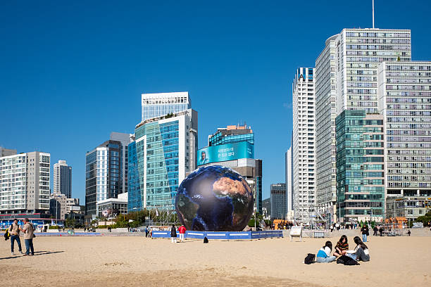 Busan, South Korea November 15, 2025. Inflatable Earth globe on Haeundae Beach in Busan, South Korea with skyscrapers and people, environmental awareness concept