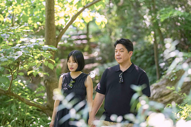 istock A man and woman are walking through a forest, holding hands 2249910814