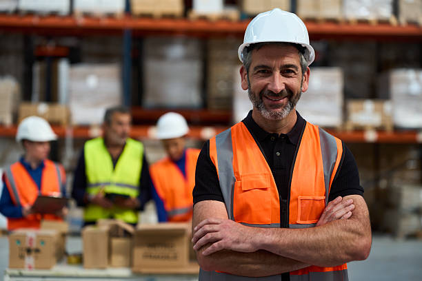 istock Mature adult warehouse worker smiling with team members 2249912737