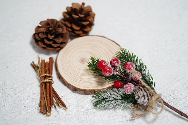istock Rustic Holiday Decor with Pine Cones, Cinnamon Sticks, Evergreen Sprigs, and Red Berries on Wooden Slice for Festive Atmosphere and Creative Crafts 2249912984
