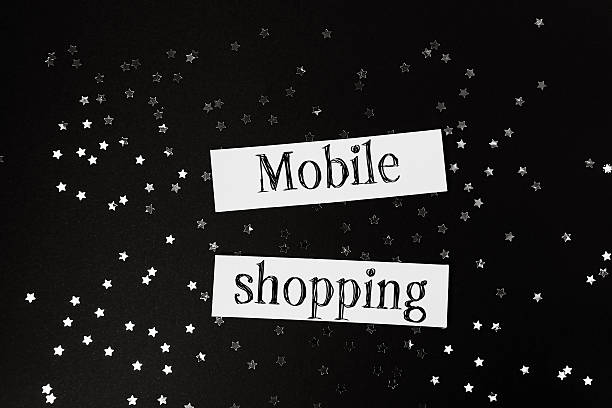 istock Mobile shopping concept with stylish typography on a dark background, surrounded by scattered silver stars, representing modern retail and online purchasing trends 2249913871