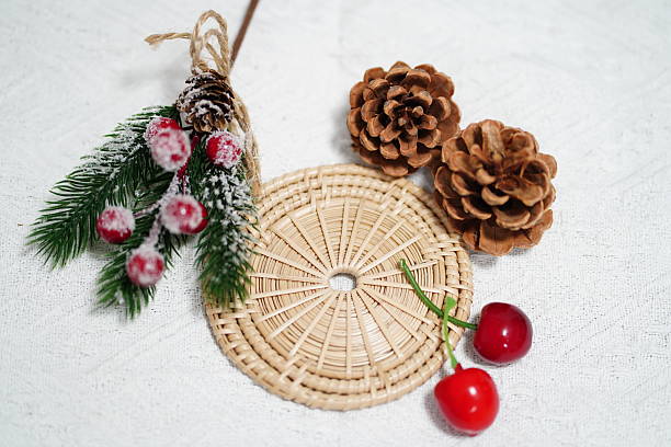 istock Festive Decor Arrangement with Frosted Berries, Pine Cones, Cherry Elements, and Woven Mat on Light Background for Holiday Theme 2249915171