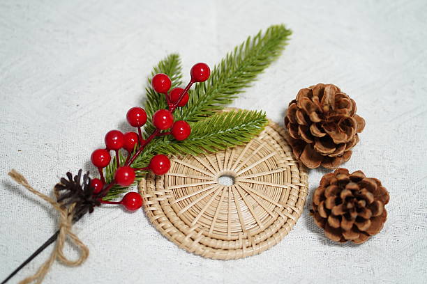 istock Decorative winter arrangement featuring pine cones, holly berries, and greenery on a textured background, ideal for festive and nature-themed projects 2249915186