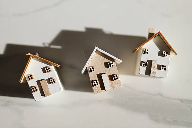 istock Miniature wooden houses on marble surface 2249915420