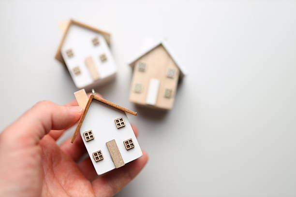 istock Hand holding miniature house model with blurred background 2249915453