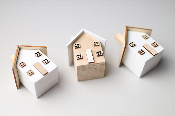 istock Wooden toy houses on white surface 2249915456
