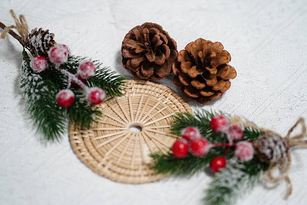 Festive Winter Arrangement with Pine Cones, Berries, and Decorative Mat on a Textured Background for Holiday-Themed Projects