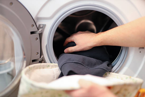 istock Caucasian male adult loading clothes into washing machine 2249915598