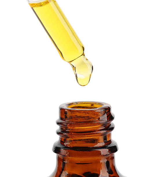 istock Dripping tincture from pipette into bottle isolated on white 2249915754