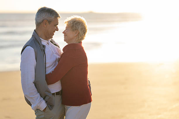 istock Senior couple embracing, smiling during romantic beach sunset 2249916581