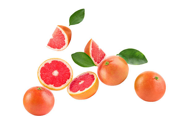 istock Fresh ripe grapefruits and green leaves falling on white background 2249916733