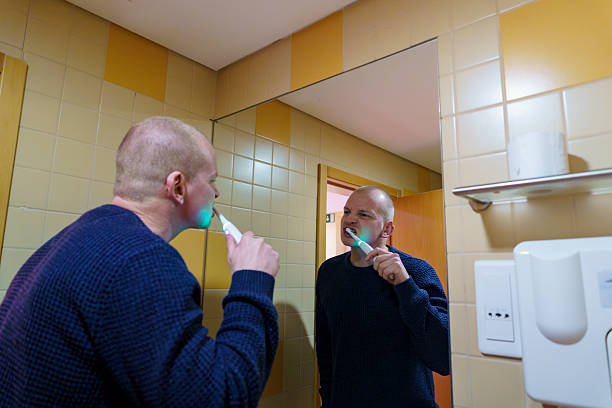 istock Man brushing teeth with electric toothbrush for oral hygiene 2249917259