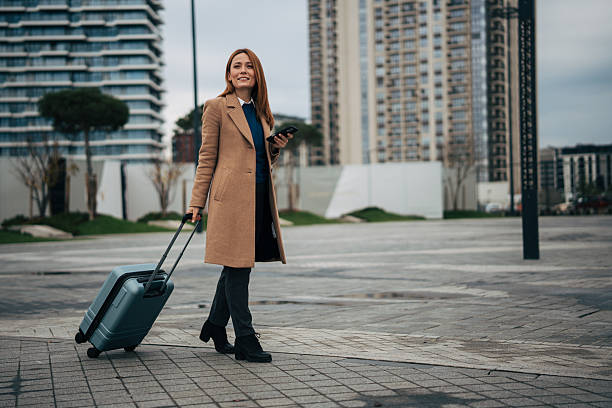 istock Woman traveling in city pulling luggage 2249917741