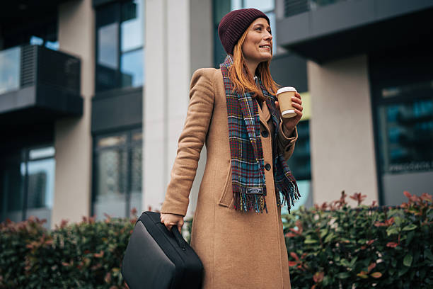 istock Happy woman commuting to work holding coffee and briefcase 2249919478