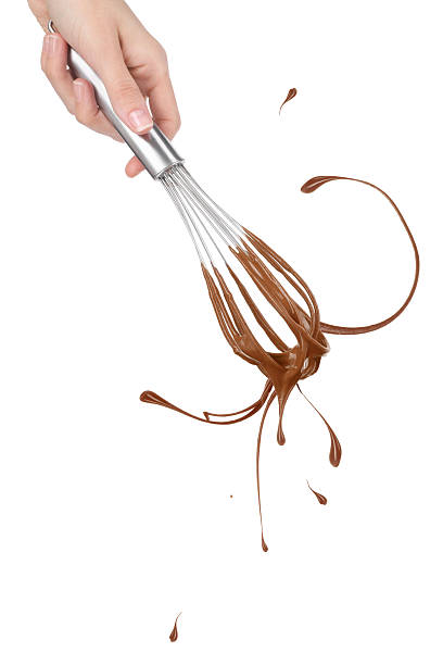 Woman holding whisk with chocolate cream on white background