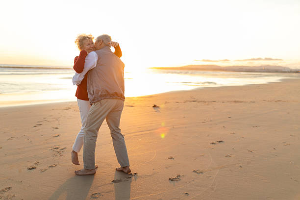 istock Senior couple embracing on beach at beautiful sunset 2249920173