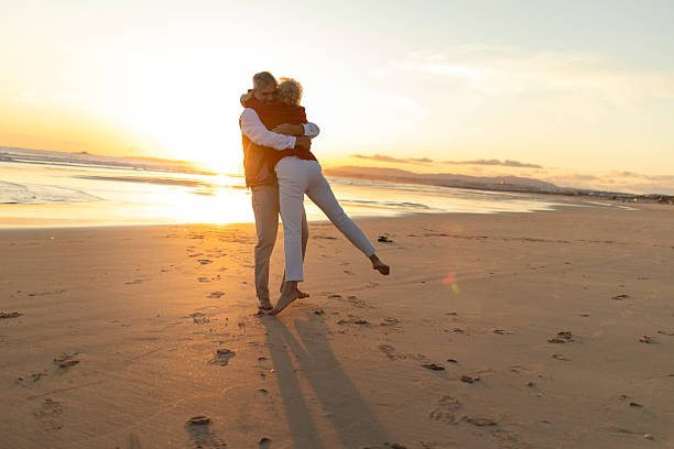 istock Senior couple embracing on beach during sunset 2249921262