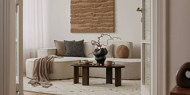 istock Earthy modern interior with round sofa, minimal coffee table, and large textured wall art in a soft natural palette. 2249921848