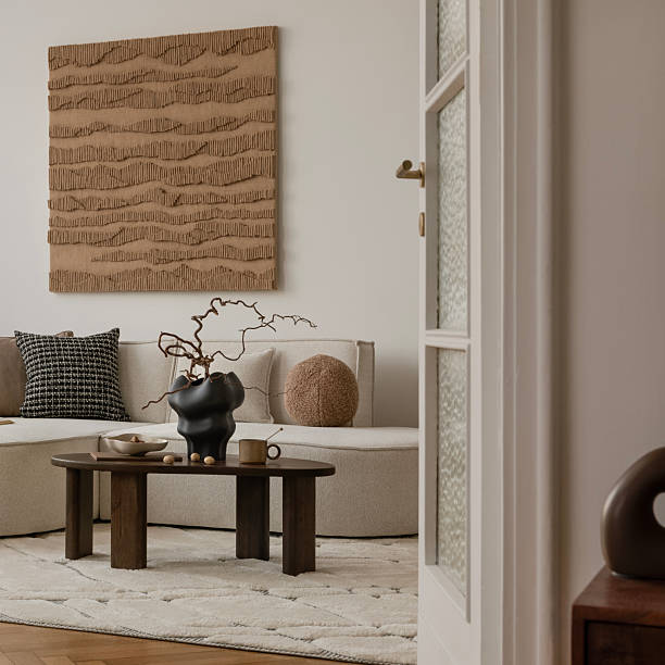istock Earthy modern interior with round sofa, minimal coffee table, and large textured wall art in a soft natural palette. 2249921892