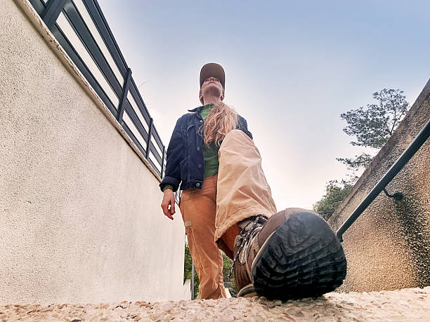 Frontal-low angle view of a woman climbing steep stairs.