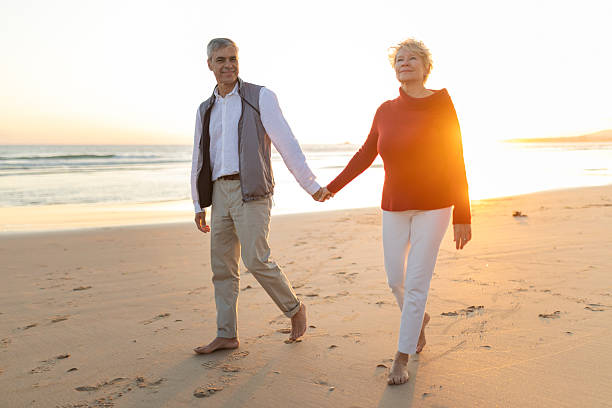 istock Senior couple enjoying romantic beach walk holding hands 2249923411