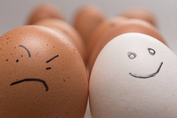 istock One smiling white egg versus 11 sad or angry brown eggs 2249927725