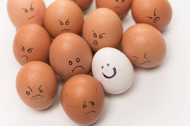 istock One smiling white egg versus 11 sad or angry brown eggs 2249927809